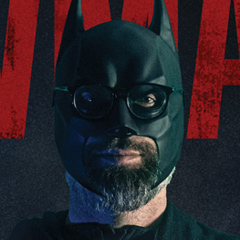 thumbnail of a man with glasses in a batman costume